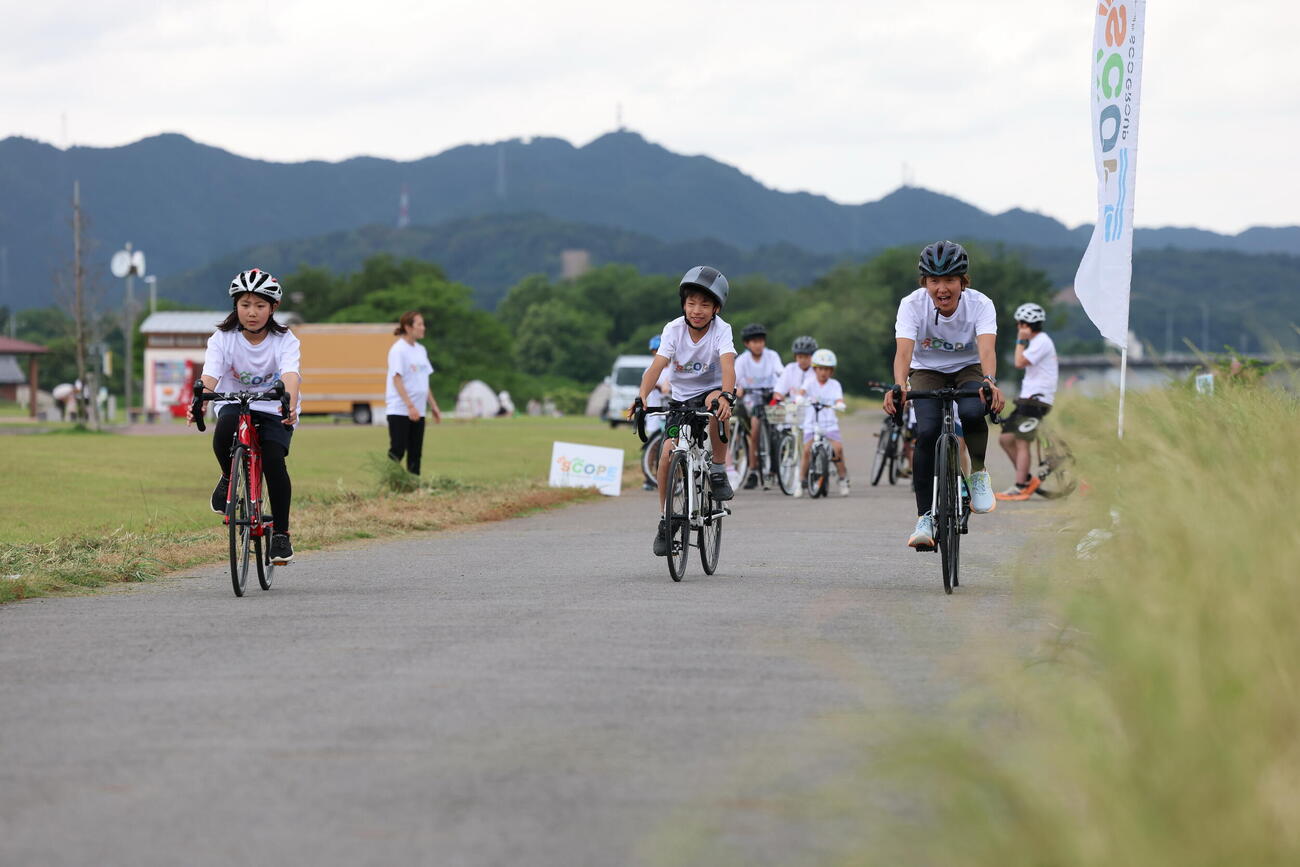 参加者にバイクを指導する関根明子氏（右）