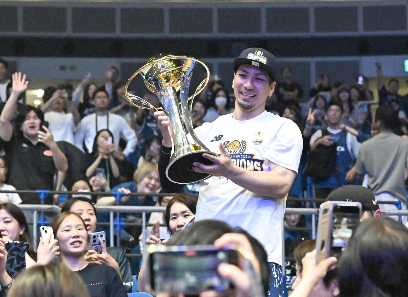 バスケBリーグ決勝第3戦　　長崎対琉球　初のBリーグチャンピオンを決めトロフィーを手に客席のファンと喜ぶ長崎の狩俣昌也（撮影・千葉一成）＝2026年5月26日