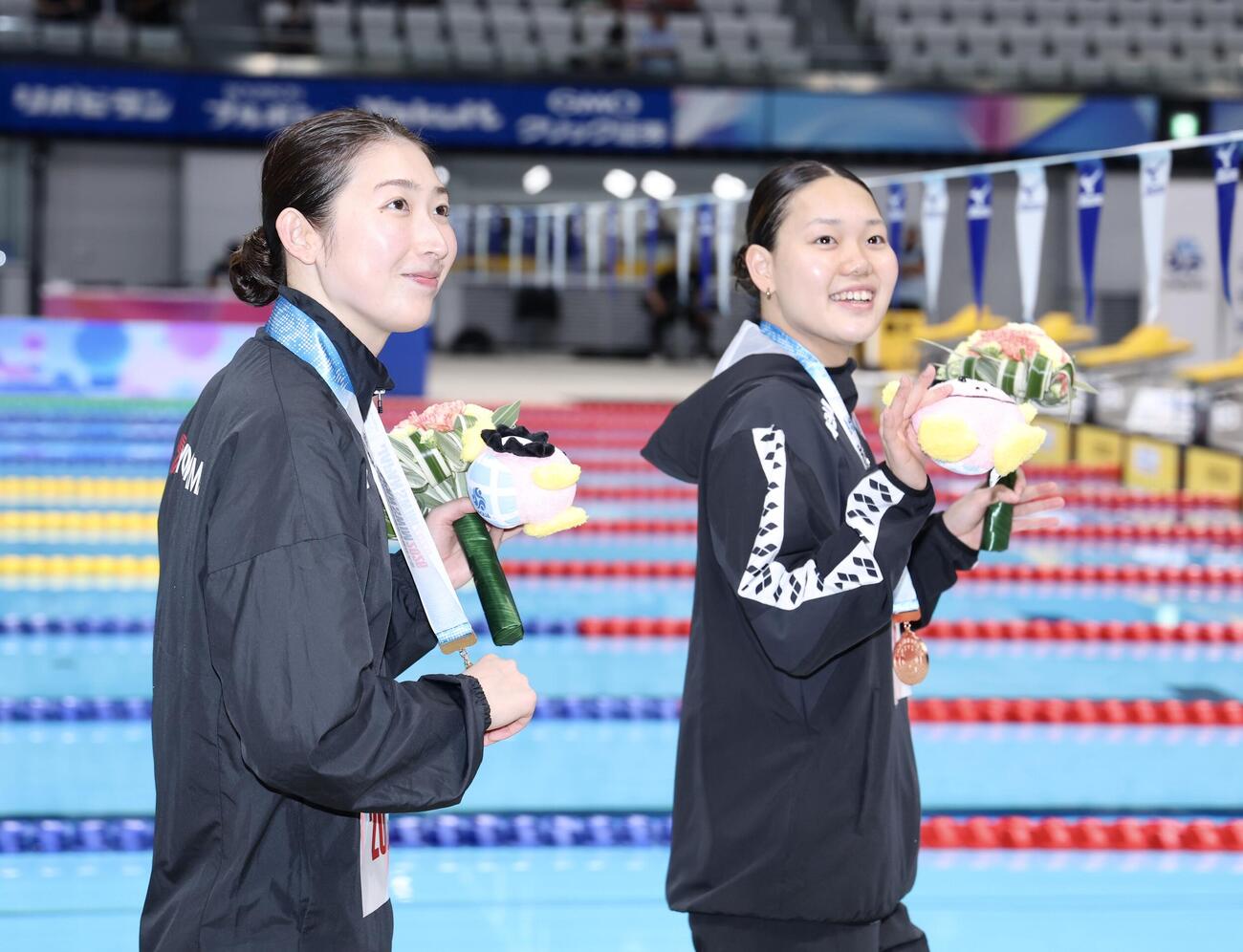 女子50メートルバタフライ決勝を終え、声援に応えながら移動する池江璃花子（左）と平井瑞希（撮影・河田真司）