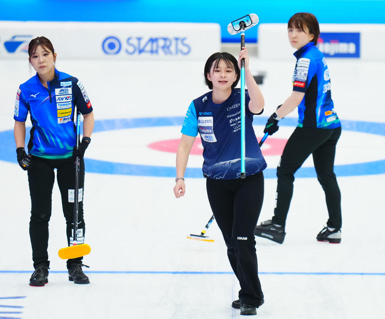 カーリング日本選手権　女子予選　ロコ・ソラーレ対SC軽井沢ク　第2エンド、ストーンを投じ笑顔を見せるSC軽井沢クの上野結生（中央）（撮影・垰建太）