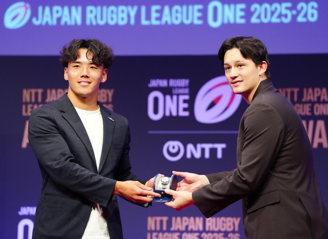ラグビー・リーグワンの表彰式で新人賞の表彰を受ける神戸の上ノ坊駿介（左）。右はプレゼンターのテーブス海（撮影・江口和貴）＝2026年6月8日