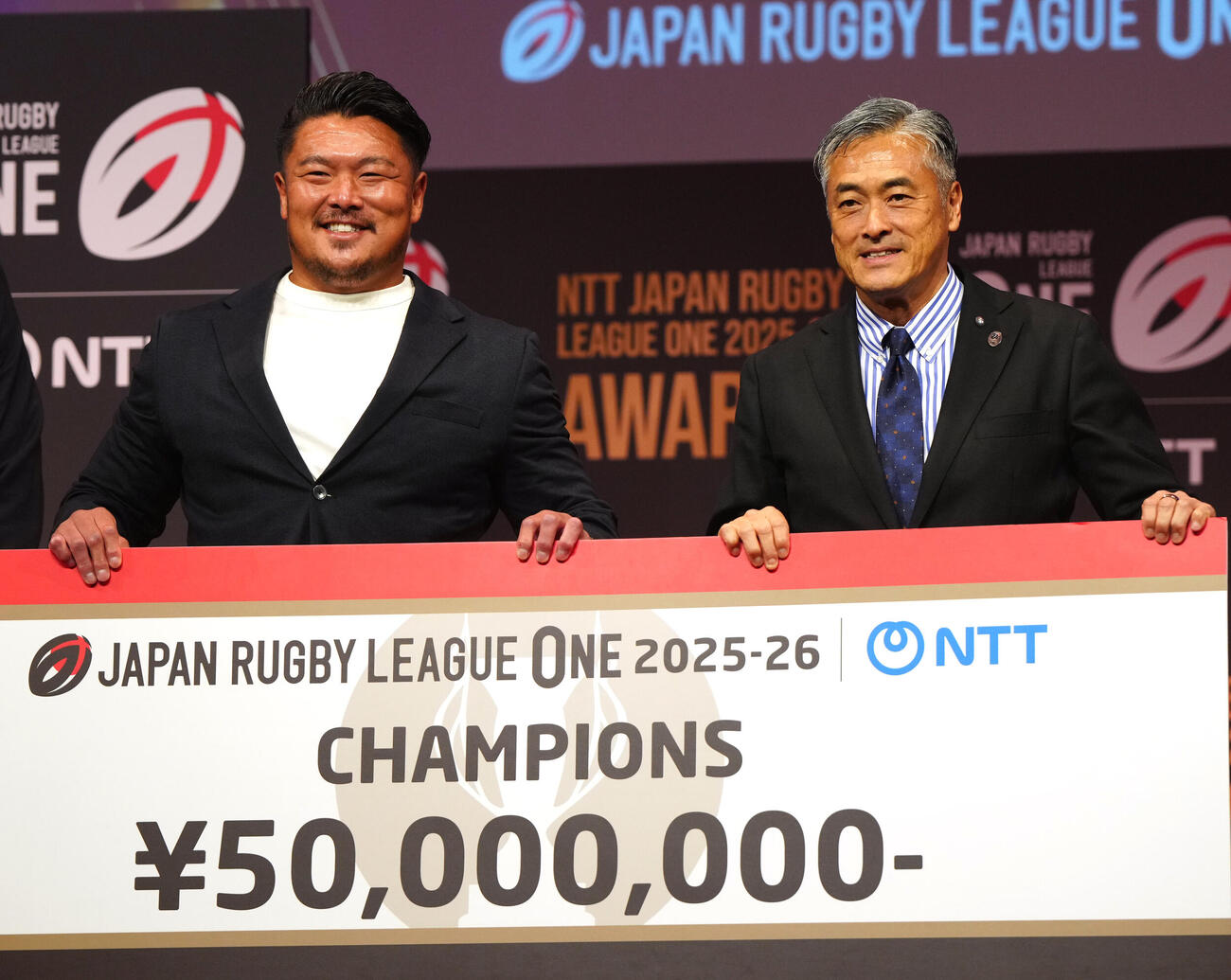 ラグビー・リーグワンの表彰式で表彰されるD1優勝神戸の山下裕史（左）。右は玉塚元一理事長（撮影・江口和貴）＝2026年6月8日
