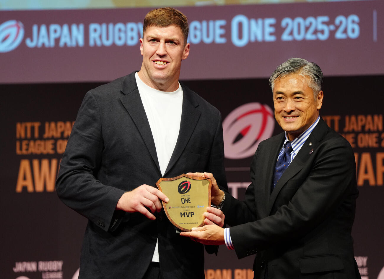 ラグビー・リーグワンの表彰式で最優秀選手賞に輝き、写真に納まる神戸のブロディ・レタリック（左）。右は玉塚元一理事長（撮影・江口和貴）＝2026年6月8日