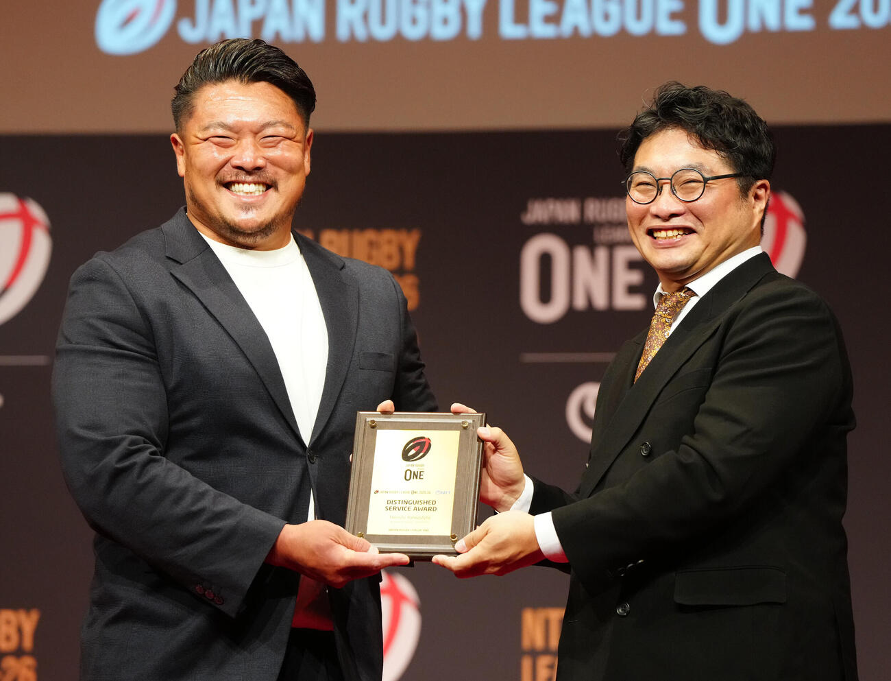 ラグビー・リーグワンの表彰式で功労賞の表彰を受ける神戸の山下裕史（左）。右は俳優の松尾諭（撮影・江口和貴）＝2026年6月8日
