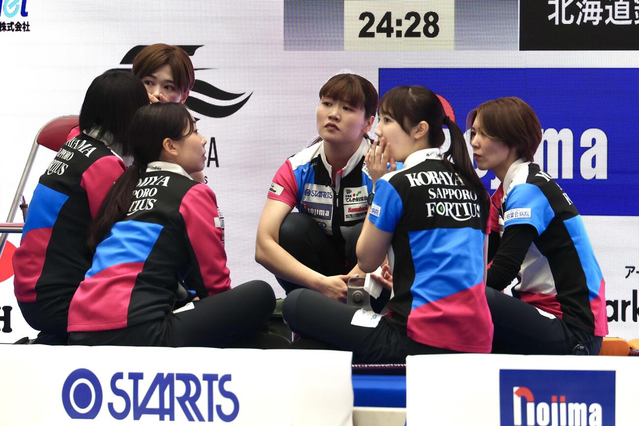 カーリング日本選手権　女子1次リーグ　フォルティウス対北海道銀行　第5エンドを終え軽食を摂るフォルティウスの選手たち（撮影・宮地輝）