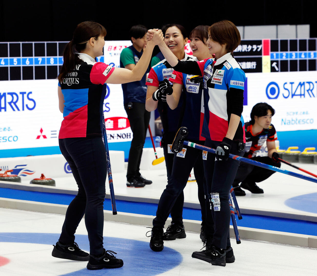 日本カーリング選手権大会　横浜2026　女子プレーオフ　中部電力対フォルティウス　第1エンド、得点を喜ぶフォルティウスの選手たち、左から小谷優奈、近江谷杏菜、小林未奈、吉村紗也香（撮影・山本朝陽）