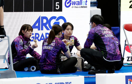 日本カーリング選手権大会 横浜2026 女子準決勝 フォルティウス対北海道銀行 第5エンド終了後、輪になって食事をする北海道銀行の選手たち(撮影・山本朝陽)=2026年6月13日