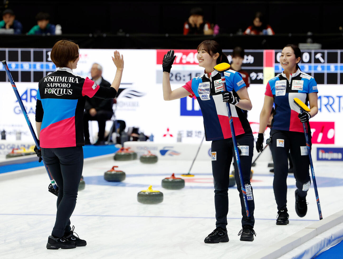 日本カーリング選手権大会　横浜2026　女子プレーオフ　中部電力対フォルティウス　第4エンド、笑顔でハイタッチをするフォルティウスの小林未奈（中央）（撮影・山本朝陽）