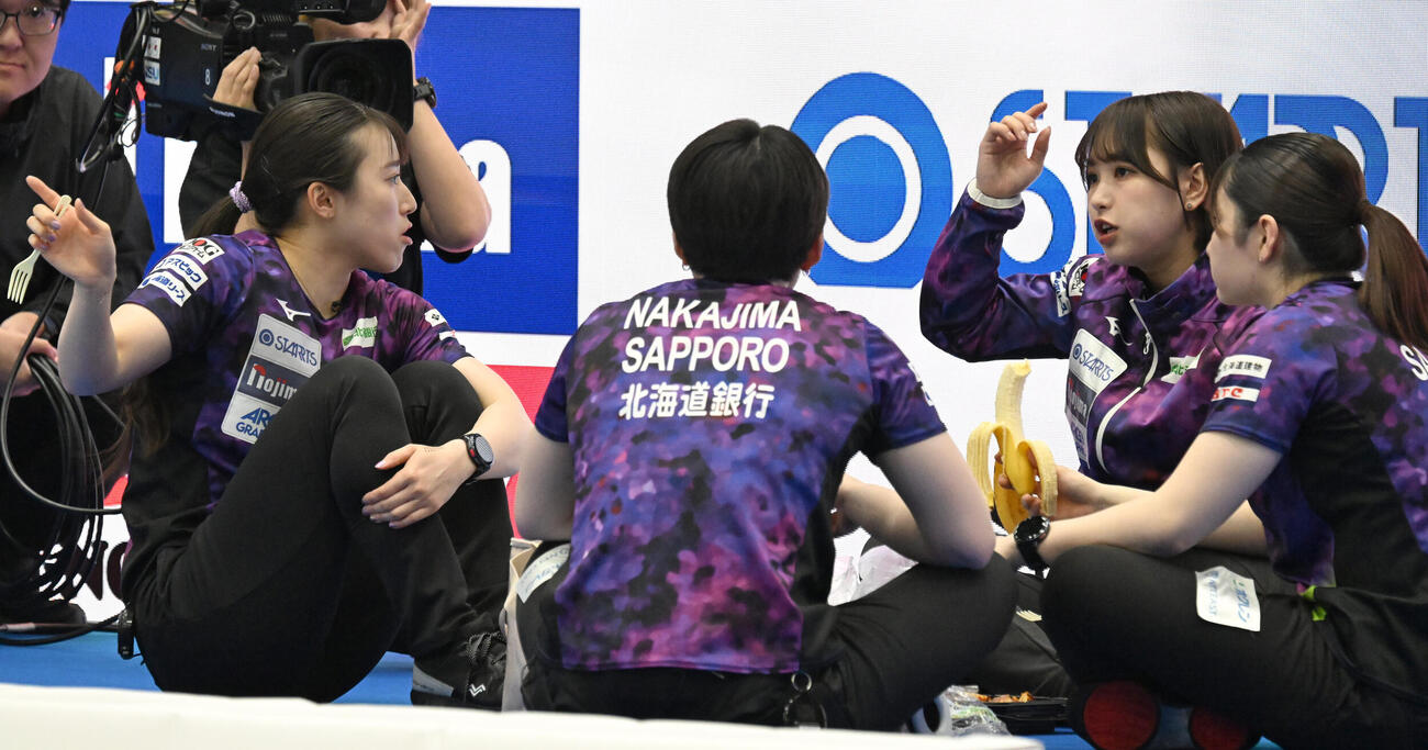 日本カーリング選手権大会横浜大会2026　女子決勝　SC軽井沢クラブ対北海道銀行　ハーフタイムに果物を食べる北海道銀行の田畑百葉（右端）ら（撮影・千葉一成）