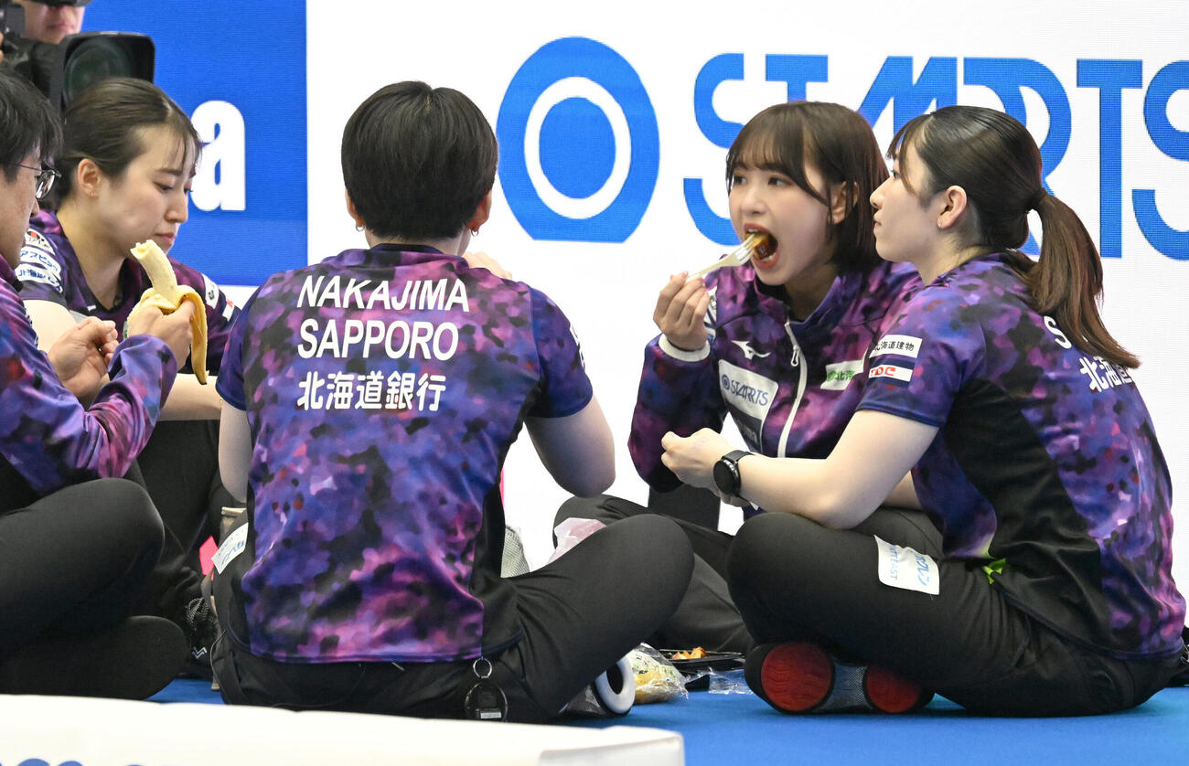 日本カーリング選手権大会横浜大会2026　女子決勝　SC軽井沢クラブ対北海道銀行　ハーフタイムにお菓子を食べる北海道銀行の仁平美来（右から2人目）ら（撮影・千葉一成）