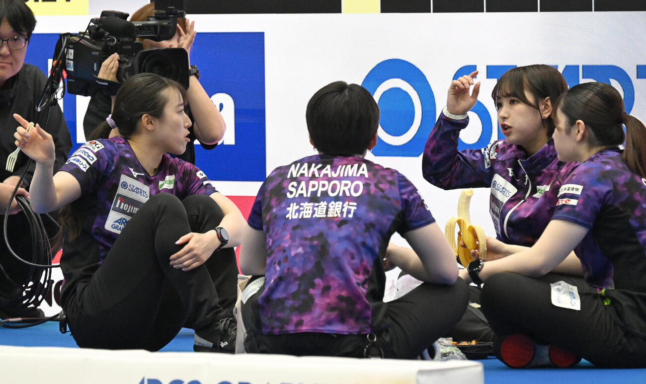 日本カーリング選手権大会横浜大会2026　女子決勝　SC軽井沢クラブ対北海道銀行　ハーフタイムにお菓子を食べる北海道銀行の仁平美来（右から2人目）ら（撮影・千葉一成）