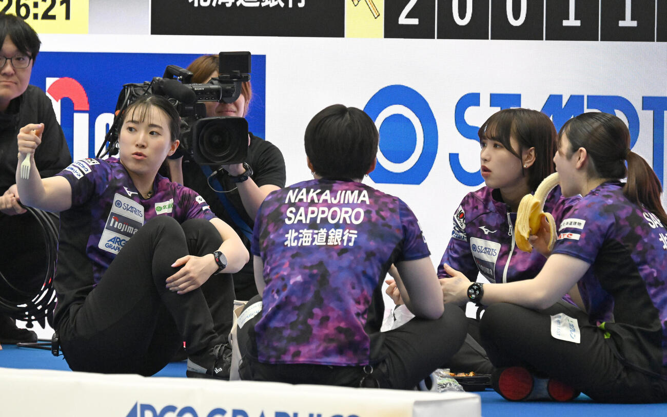 日本カーリング選手権大会横浜大会2026　女子決勝　SC軽井沢クラブ対北海道銀行　ハーフタイムに果物を食べる北海道銀行の山本冴（左端）ら（撮影・千葉一成）