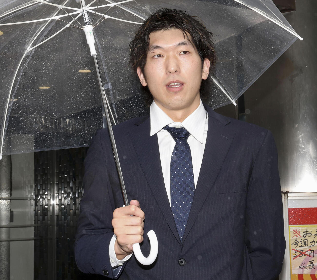 保釈され、報道陣に対応するバレーボール元日本代表の佐藤駿一郎被告＝18日午前、東京都港区（共同）