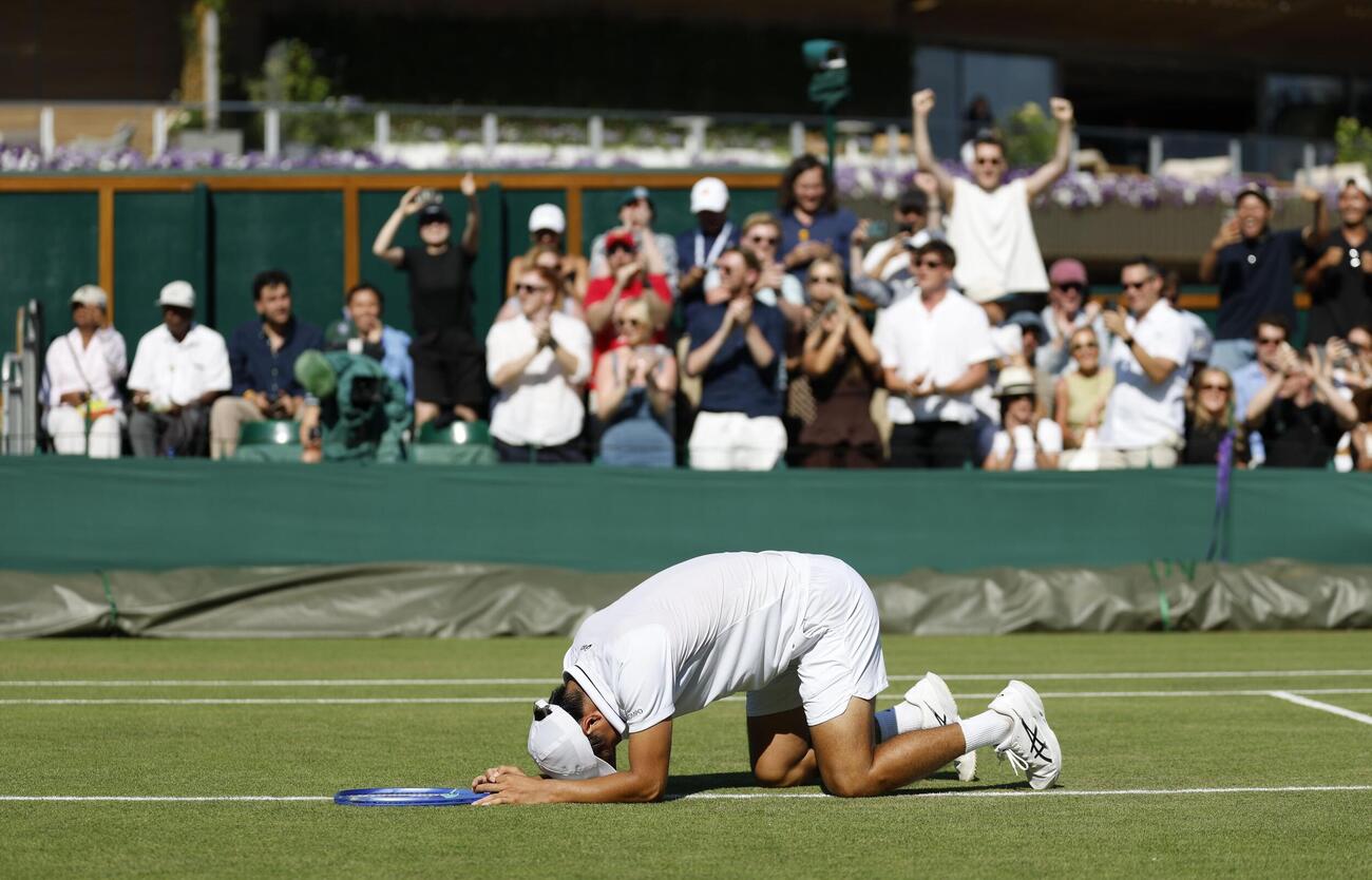 男子シングルス3回戦で勝利し、コートに倒れ込む望月慎太郎＝ウィンブルドン（共同）