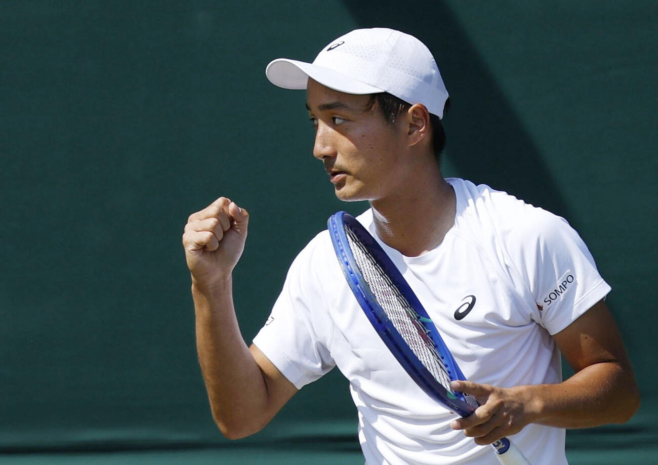 男子シングルス3回戦でポイントを奪い、ガッツポーズする望月慎太郎＝ウィンブルドン（共同）