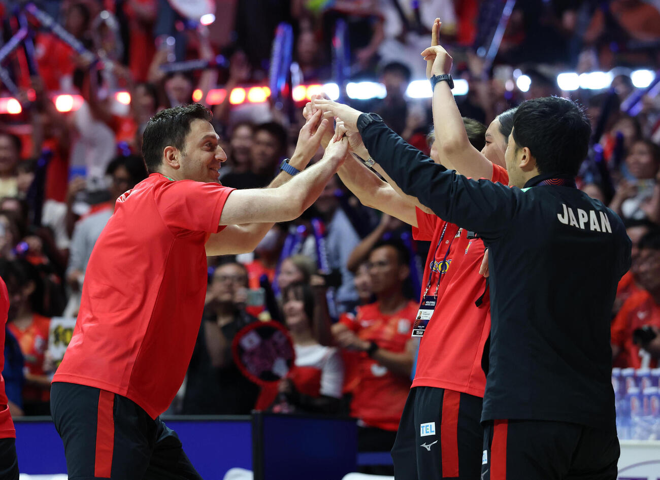 日本対ポーランド　決勝ラウンド進出を決めスタッフとハイタッチして喜ぶ日本代表のフェルハト・アクバシュ監督（左）（撮影・白石智彦）