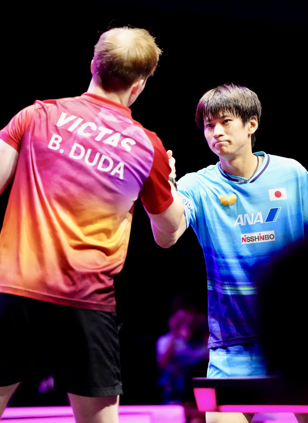 男子シングルス1回戦　ドイツのドゥダ（左）に敗れ、試合後、握手を交わす戸上隼輔（撮影・江口和貴）