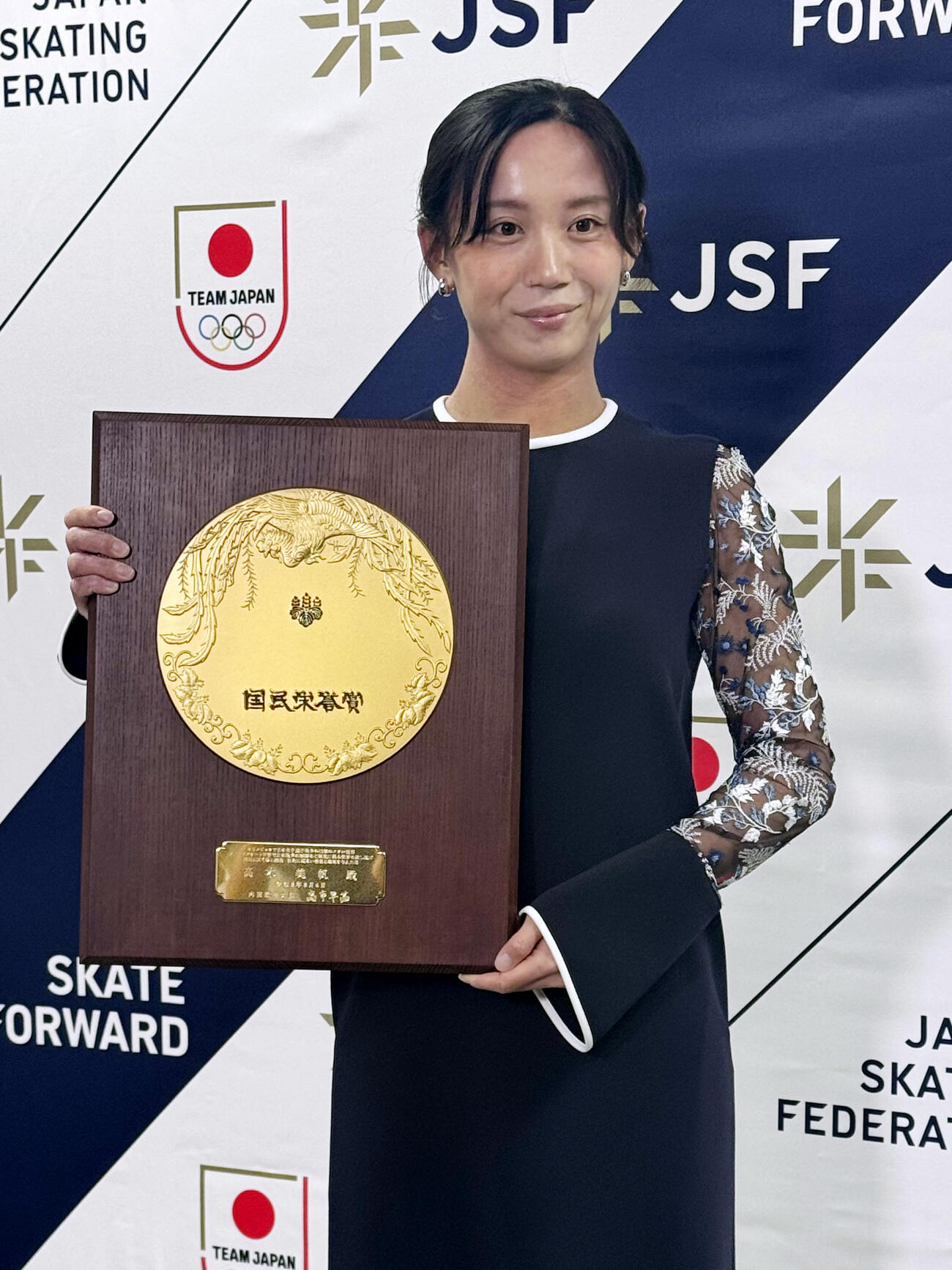 国民栄誉賞の記念の盾を手に記念撮影に応じる高木美帆さん（共同）
