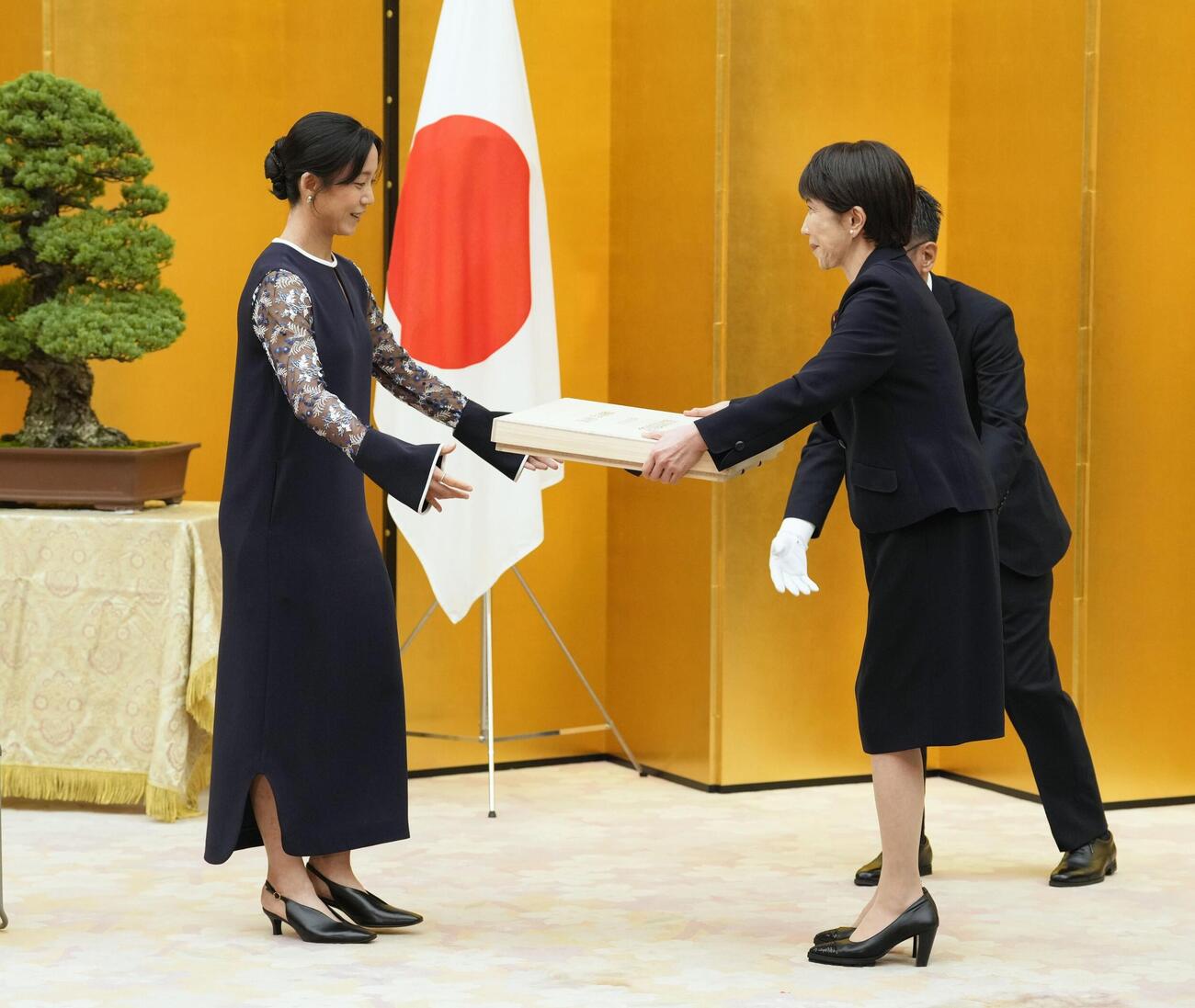 国民栄誉賞表彰式で、高市首相（右）から記念品を受け取るスピードスケートの高木美帆さん（共同）