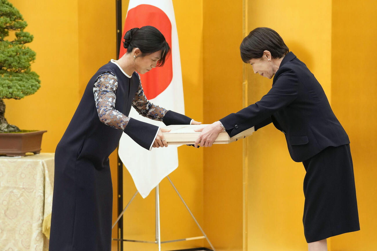国民栄誉賞表彰式で、高市首相（右）から記念品を受け取るスピードスケートの高木美帆さん（共同）