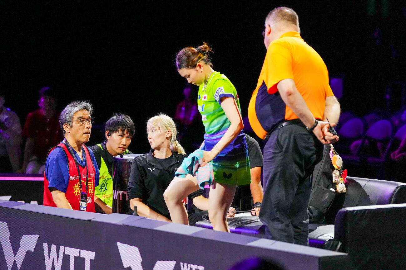 女子シングルス1回戦、張本美和との対戦で、第2ゲーム終了後、医療班と話す橋本帆乃香（撮影・江口和貴）