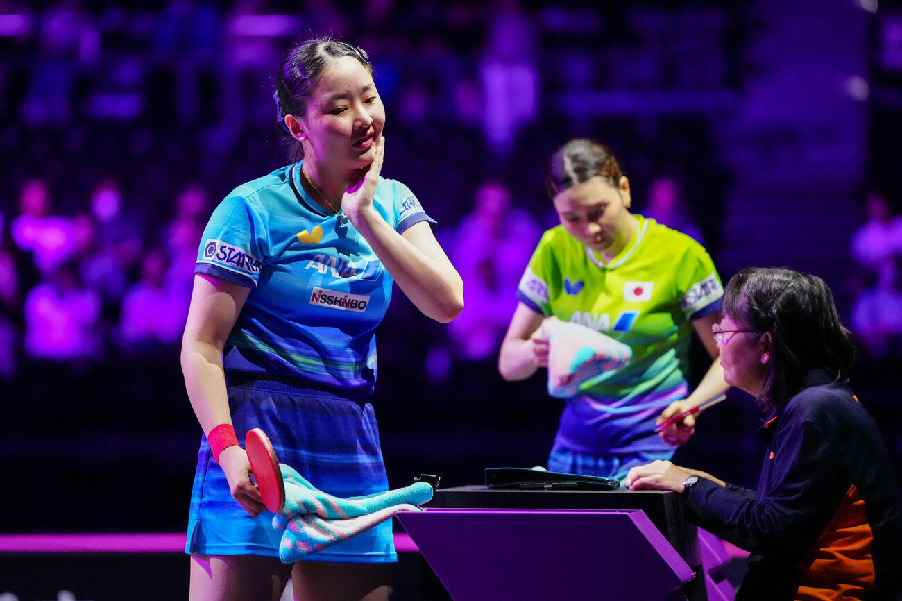 女子シングルス1回戦　第5ゲーム、汗をぬぐう張本美和（左）。後方は橋本帆乃香（撮影・江口和貴）