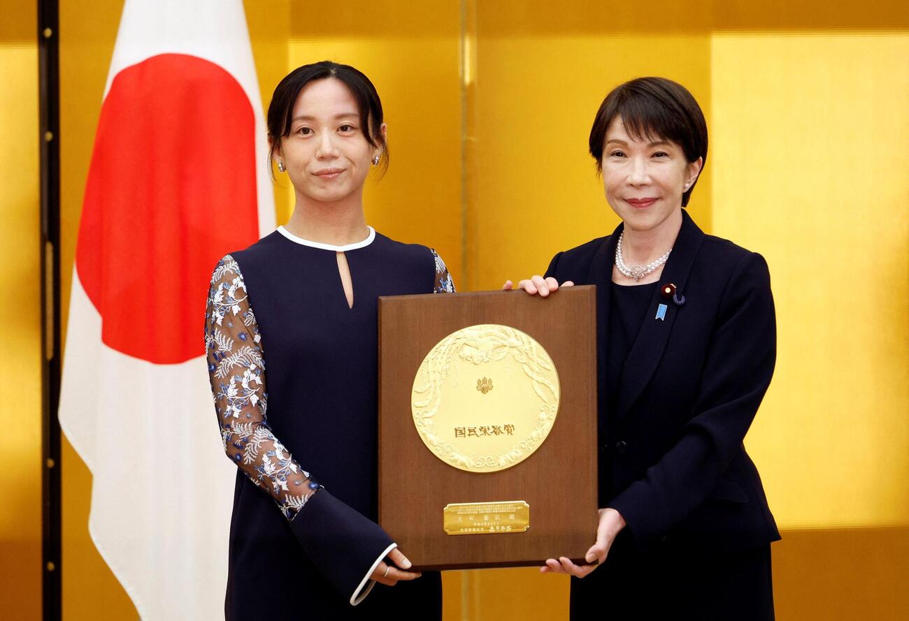 2026年8月4日、首相官邸で行われた授与式で、国民栄誉賞の盾を手にする高市早苗首相と高木美帆さん（ロイター）