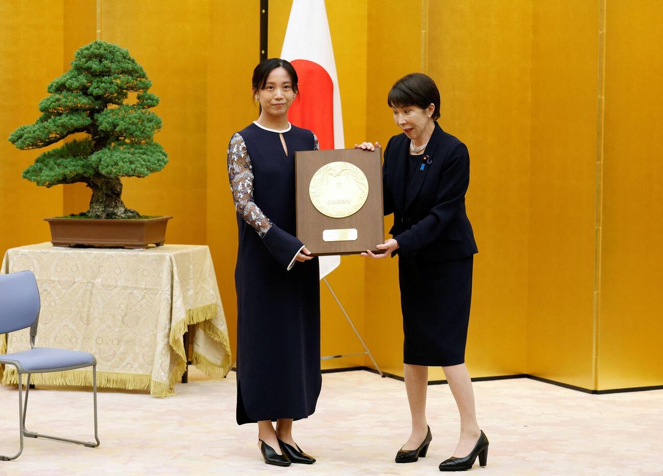 26年8月4日　国民栄誉賞表彰式で、高市首相（右）から盾を受け取るスピードスケートの高木美帆さん（ロイター）