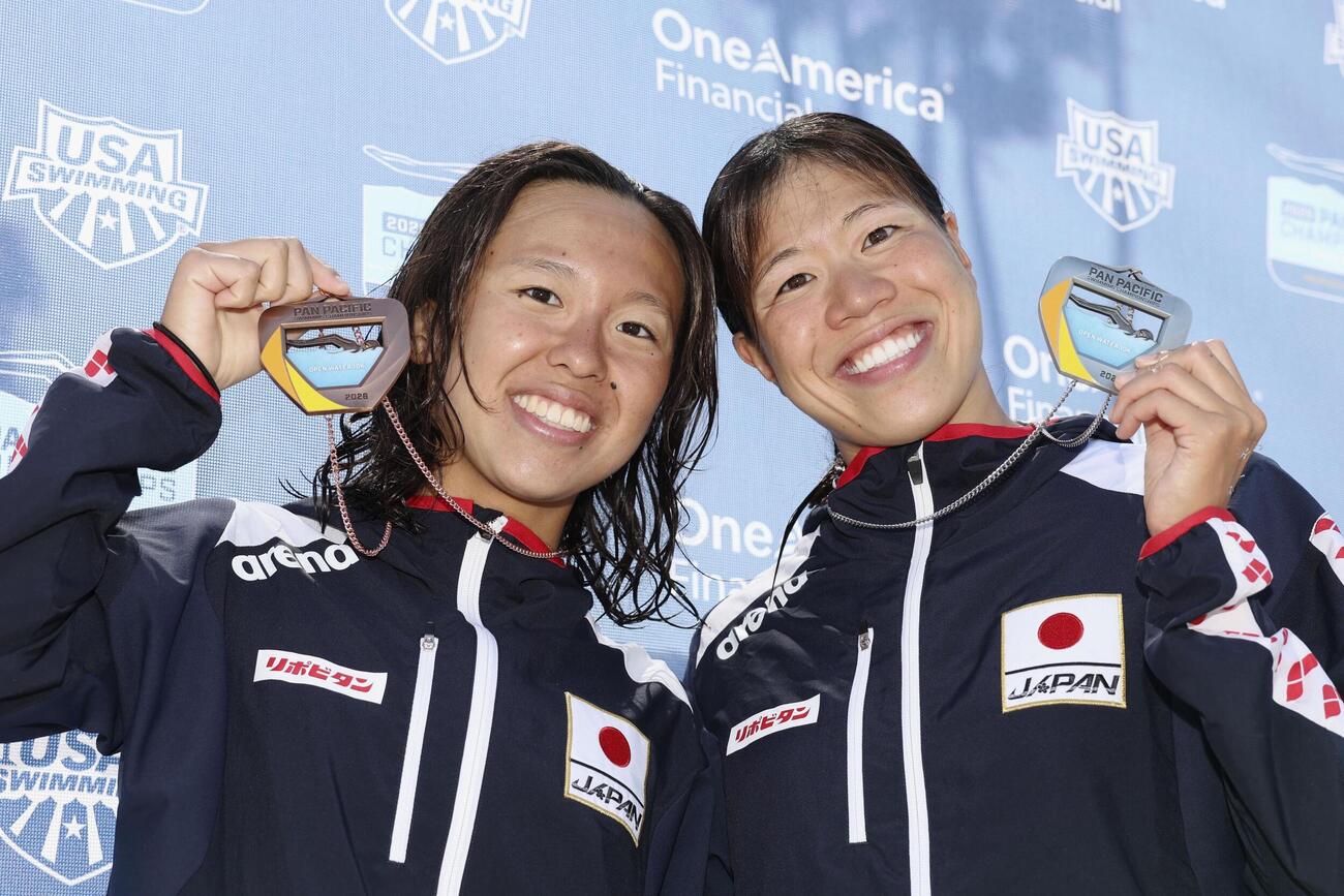 女子10キロで2位となりメダルを掲げる蝦名愛梨（右）と3位の梶本一花（共同）