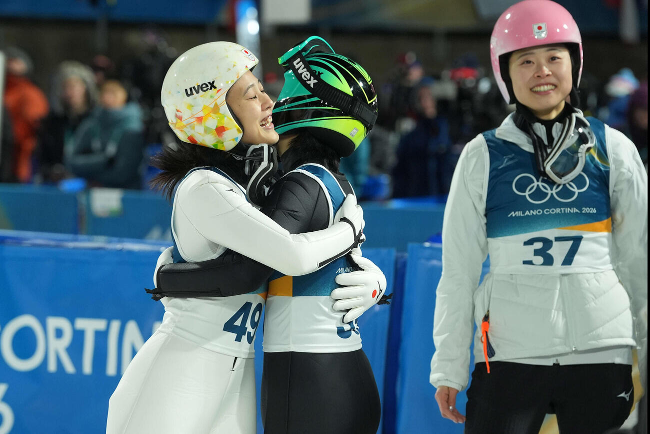 2026年2月、ミラノ・コルティナ冬季五輪女子個人ラージヒルで飛躍を終え、伊藤（中央）とハグする丸山希