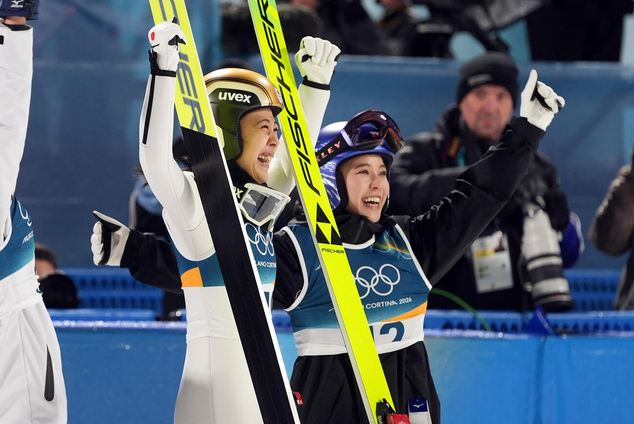 2026年2月、ミラノ・コルティナ冬季五輪ジャンプ女子個人ノーマルヒル決勝で銅メダルを獲得しポーズを決める丸山希。右は高梨