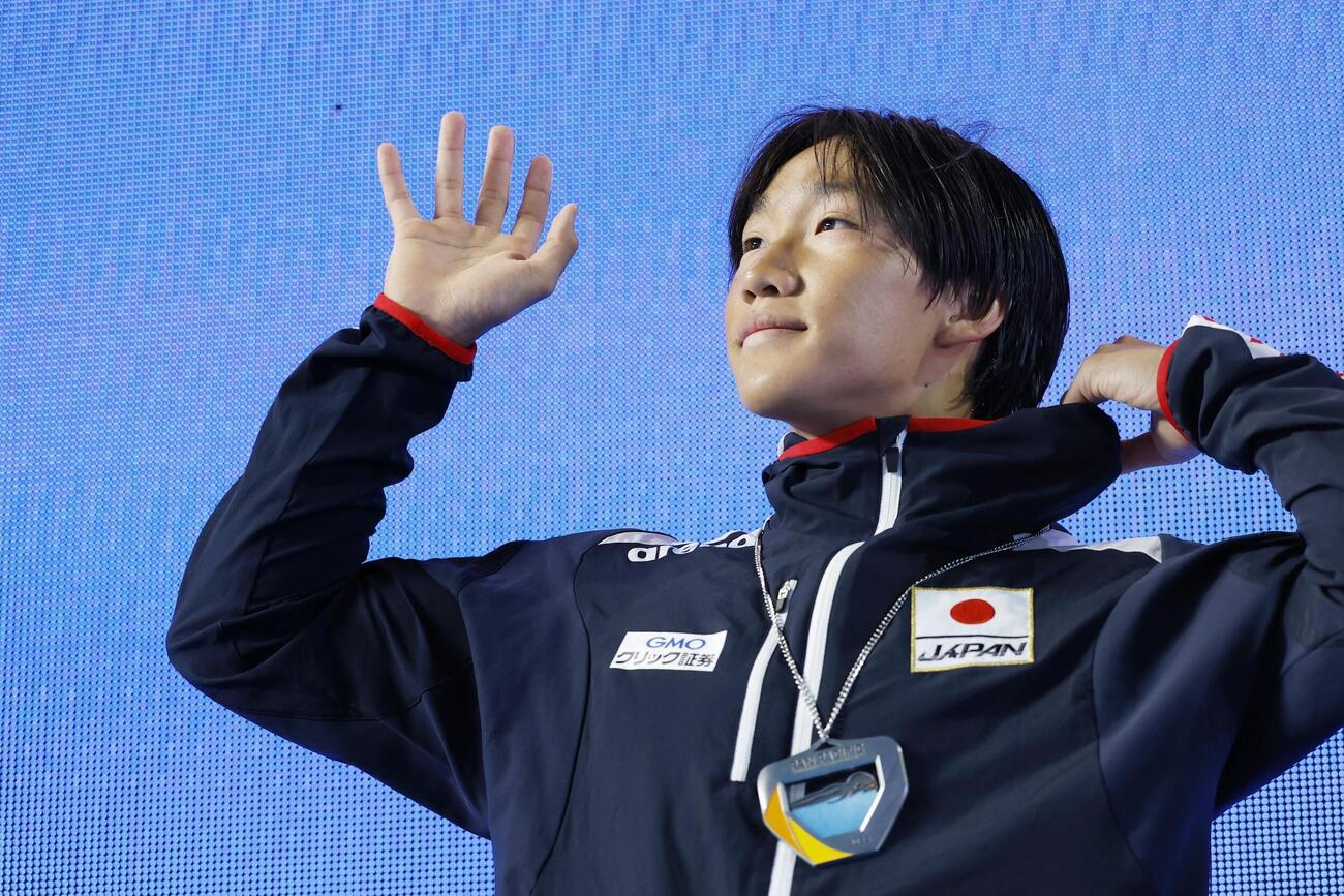 男子100メートル平泳ぎで2位に入り、表彰式で声援に応える大橋信＝アーバイン（共同）