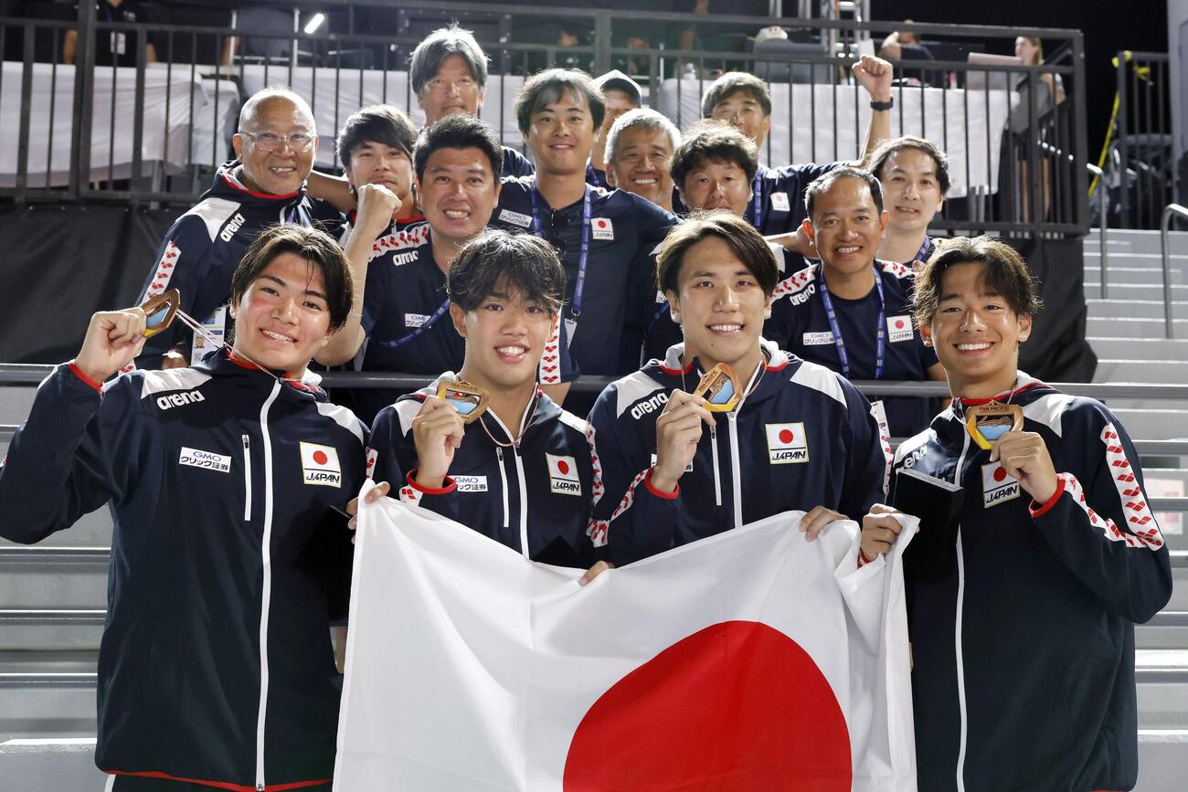 男子800メートルリレーで3位となり関係者らと写真に納まる（手前左から）松下知之、黒田一瑳、松元克央、村佐達也＝アーバイン（共同）