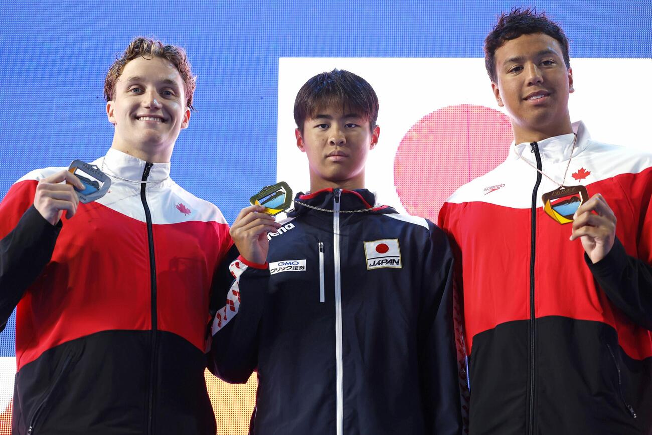 男子200メートル背泳ぎで優勝した小島夢貴（中央）＝アーバイン（共同）