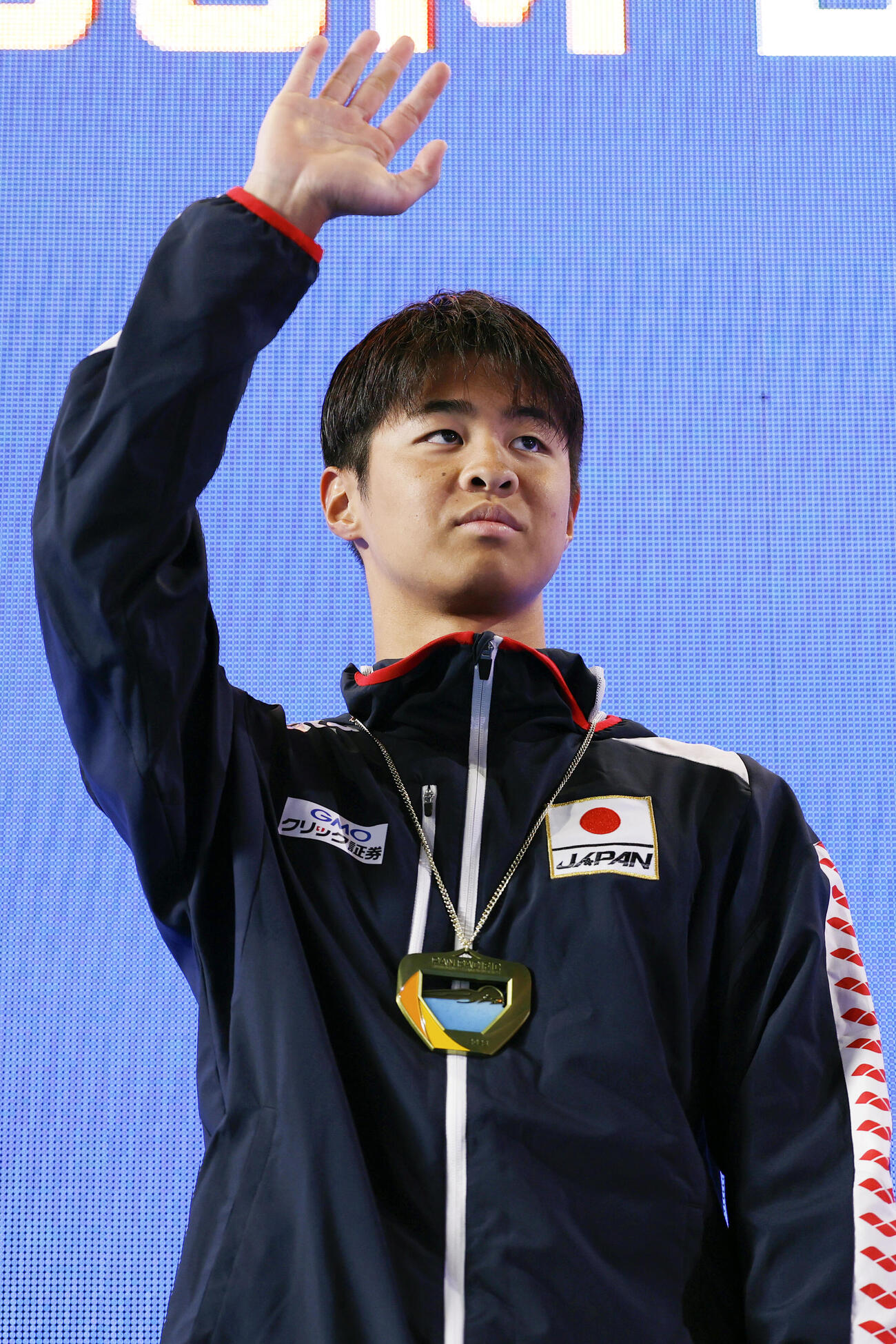 男子200メートル背泳ぎで優勝し、表彰式で歓声に応える小島夢貴＝アーバイン（共同）
