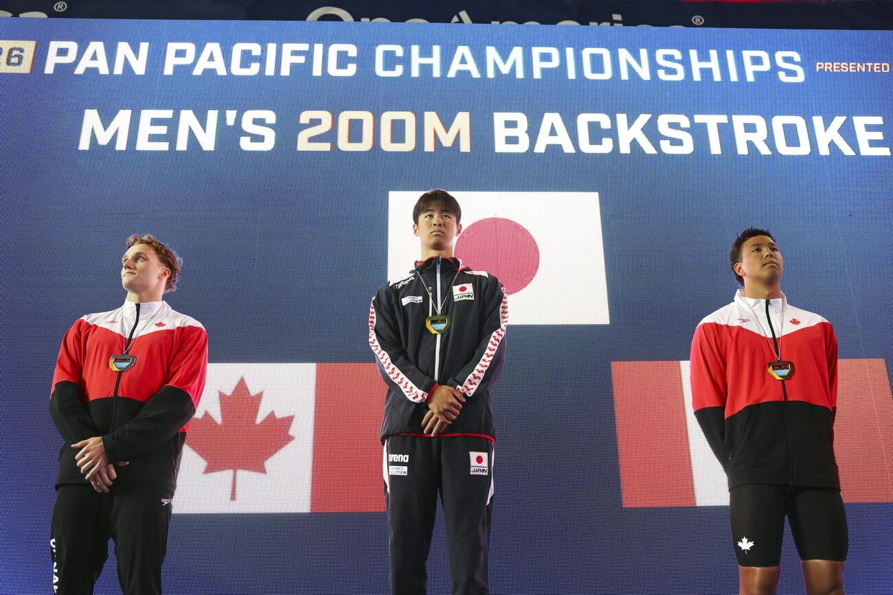 男子200メートル背泳ぎで優勝した小島夢貴（中央）＝アーバイン（共同）