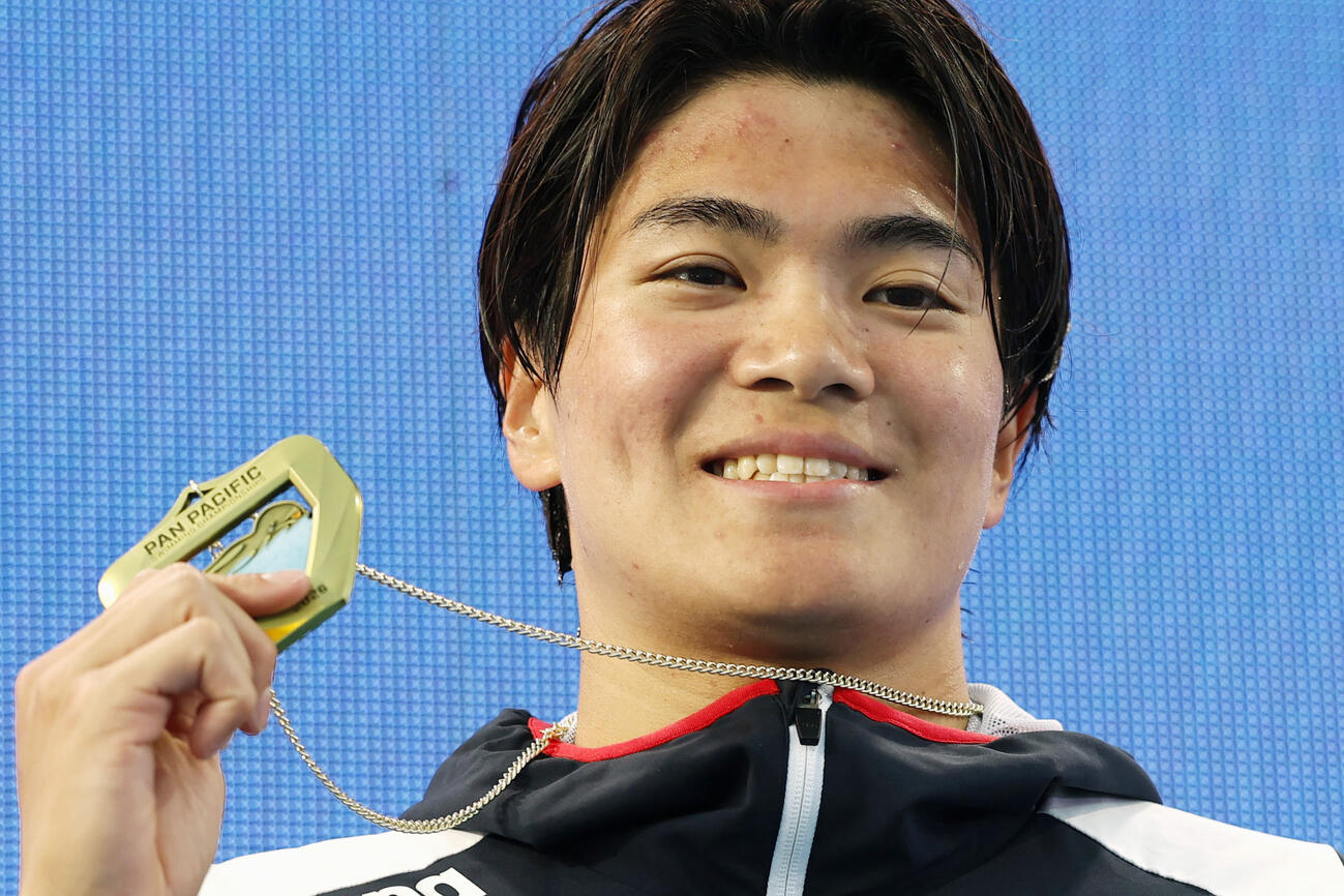 男子200メートル個人メドレーで優勝し、メダルを掲げる松下知之＝アーバイン（共同）