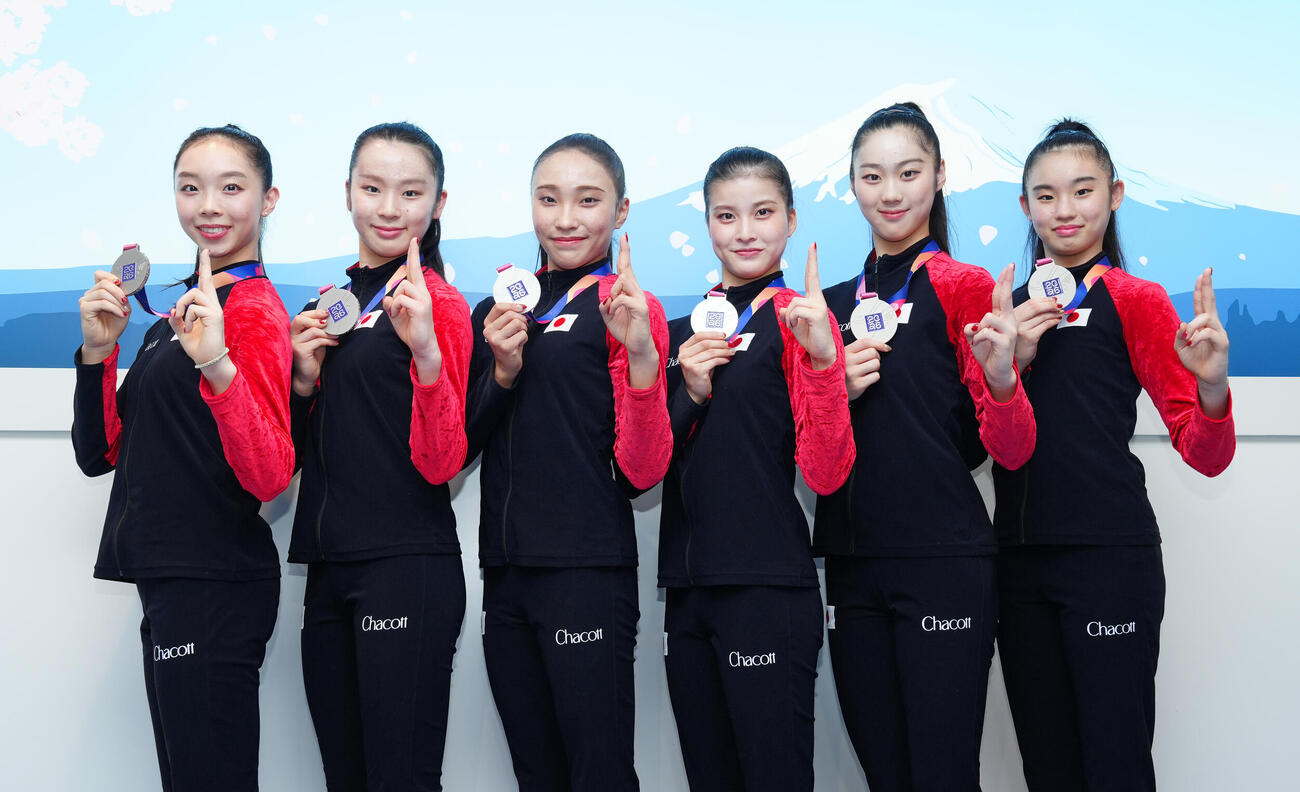 ロサンゼルス五輪の出場権を獲得し、帰国したフェアリージャパンは世界選手権の銀メダルを手に笑顔で写真に納まる。左から田辺観世埜、田中友菜、田口久乃、西本愛実、花村夏実、真鍋凛（撮影・鈴木みどり）