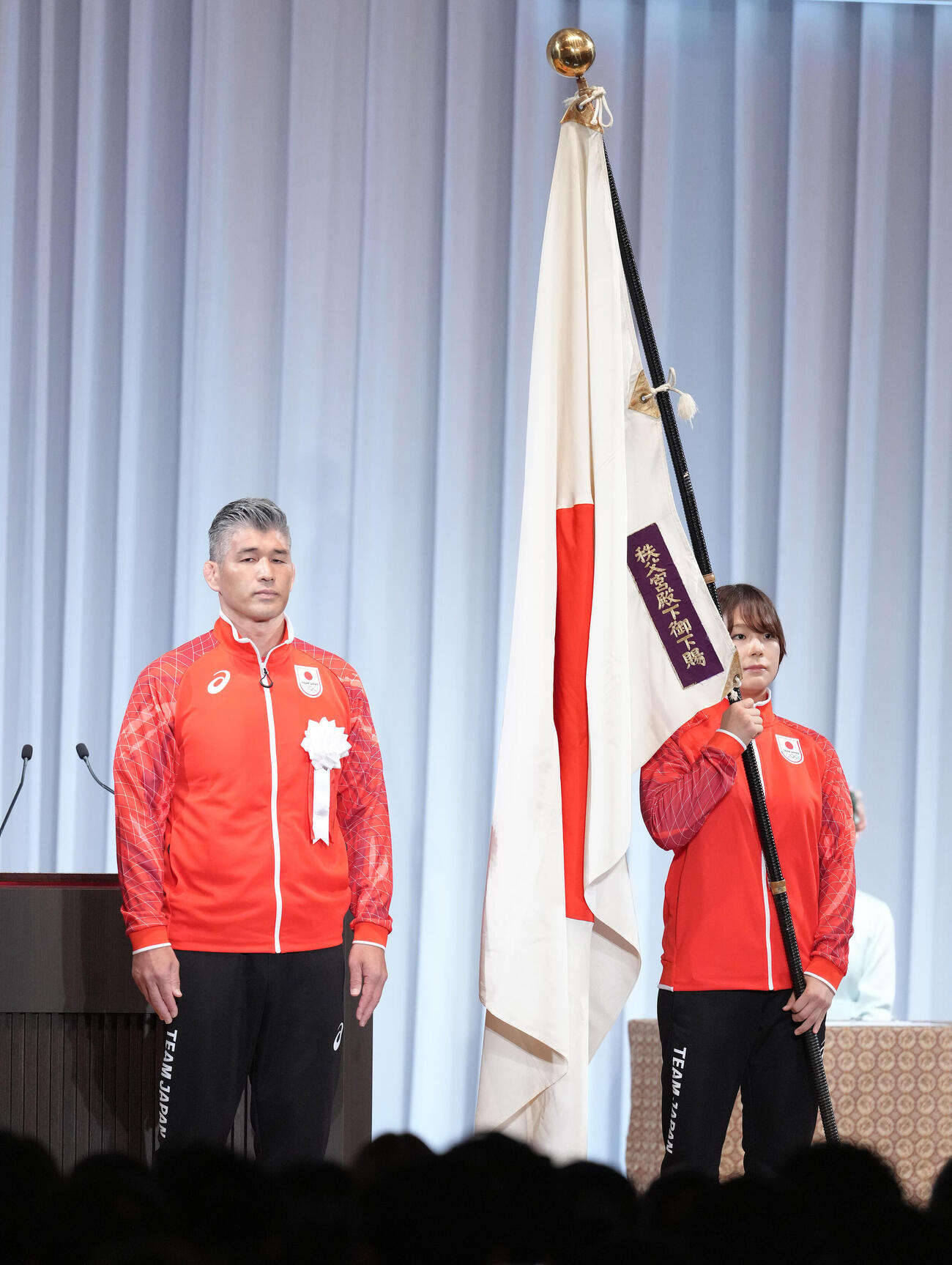 アジア大会TEAM JAPAN結団式で団旗を受け取った藤波朱理（右）。左は井上康生団長（撮影・足立雅史）