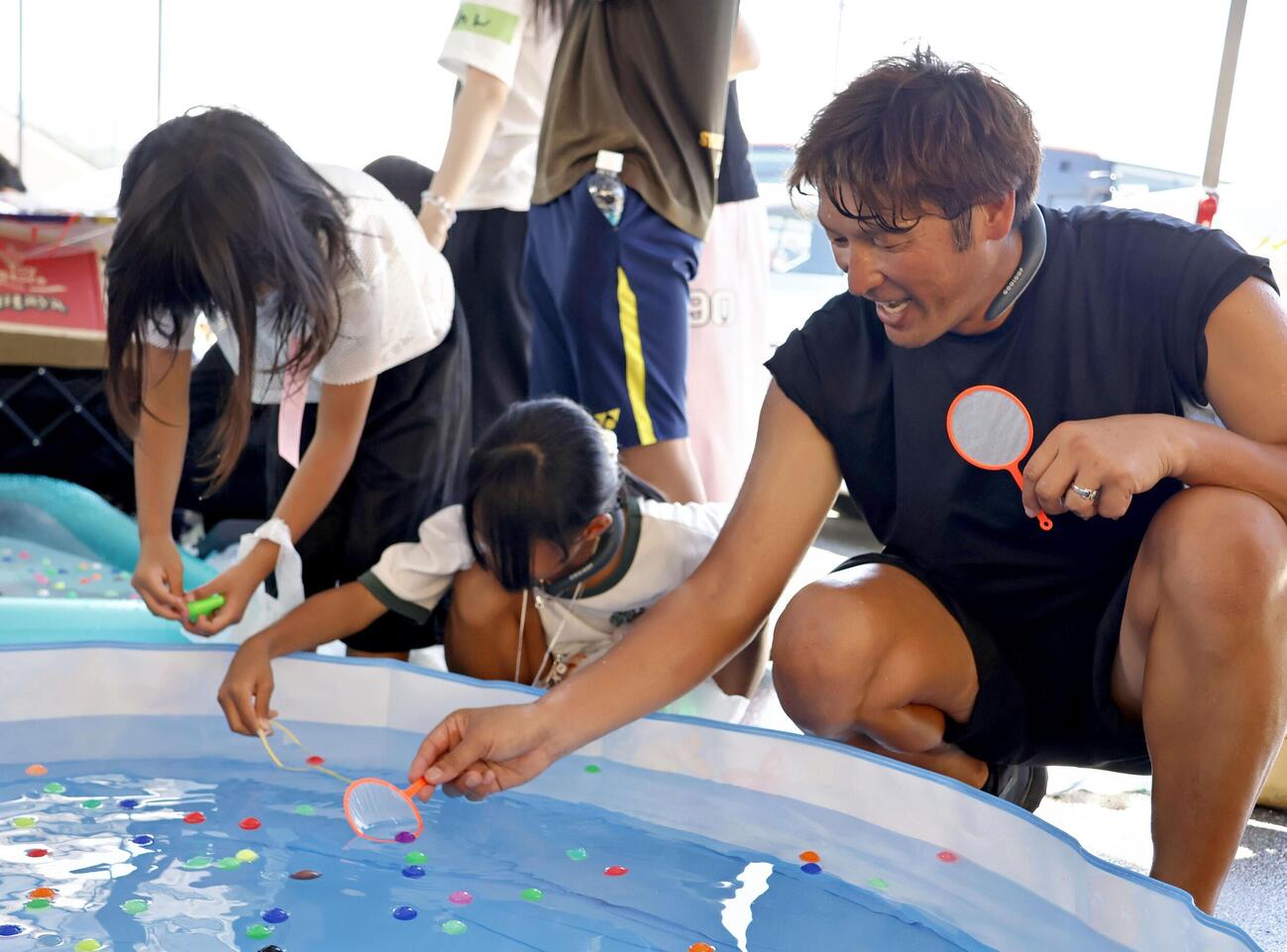 熊本県宇城市の小川防災拠点センターで子どもたちと交流するサッカー元日本代表の巻誠一郎さん（右）（共同）