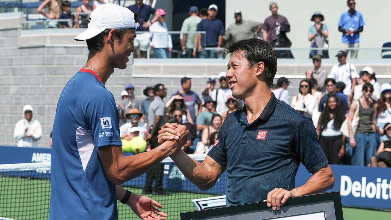 男子シングルス予選3回戦の試合後に行われたセレモニーで坂本怜（左）と握手する錦織圭＝ニューヨーク（USTA／ゲッティ＝共同）