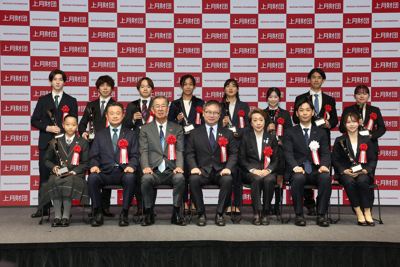 「上月スポーツ賞」表彰式後に写真に納まる、前列左から前列左から南埜佑芽、コナミグループ株式会社東尾公彦代表取締役社長、日本スポーツ協会森岡裕策専務理事、河合純一スポーツ庁長官、橋本聖子JOC会長、上月財団村田哲也常務理事、杉原愛子、後列左から中田璃士、佐藤駿、鍵山優真、高木美帆さん、坂本花織さん、中井亜美、堀島行真、田中沙季（撮影・河田真司）