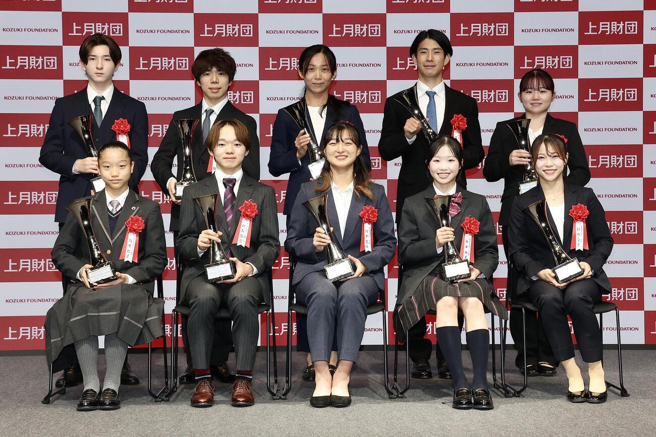 トロフィーを手に笑顔で写真に納まる「上月スポーツ賞」受賞者たち。前列左から南埜佑芽、鍵山優真、坂本花織さん、中井亜美、杉原愛子、後列左から中田璃士、佐藤駿、高木美帆さん、堀島行真、田中沙季（撮影・河田真司）