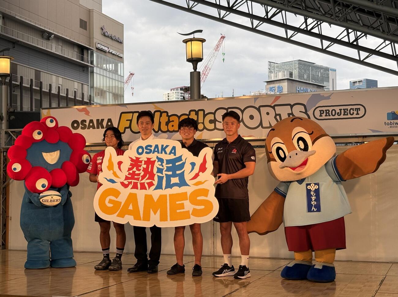 「OSAKA FUNtast!c SPORTS PROJECT」の告知イベントに登壇した（左から）ミャクミャク、大阪SH山内俊央、吉村洋文知事、花園SH河村謙尚、栃木SH北條拓郎、もずやん