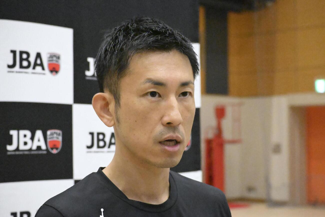 取材に応じるアジア大会バスケットボール男子日本代表の吉本監督（共同）