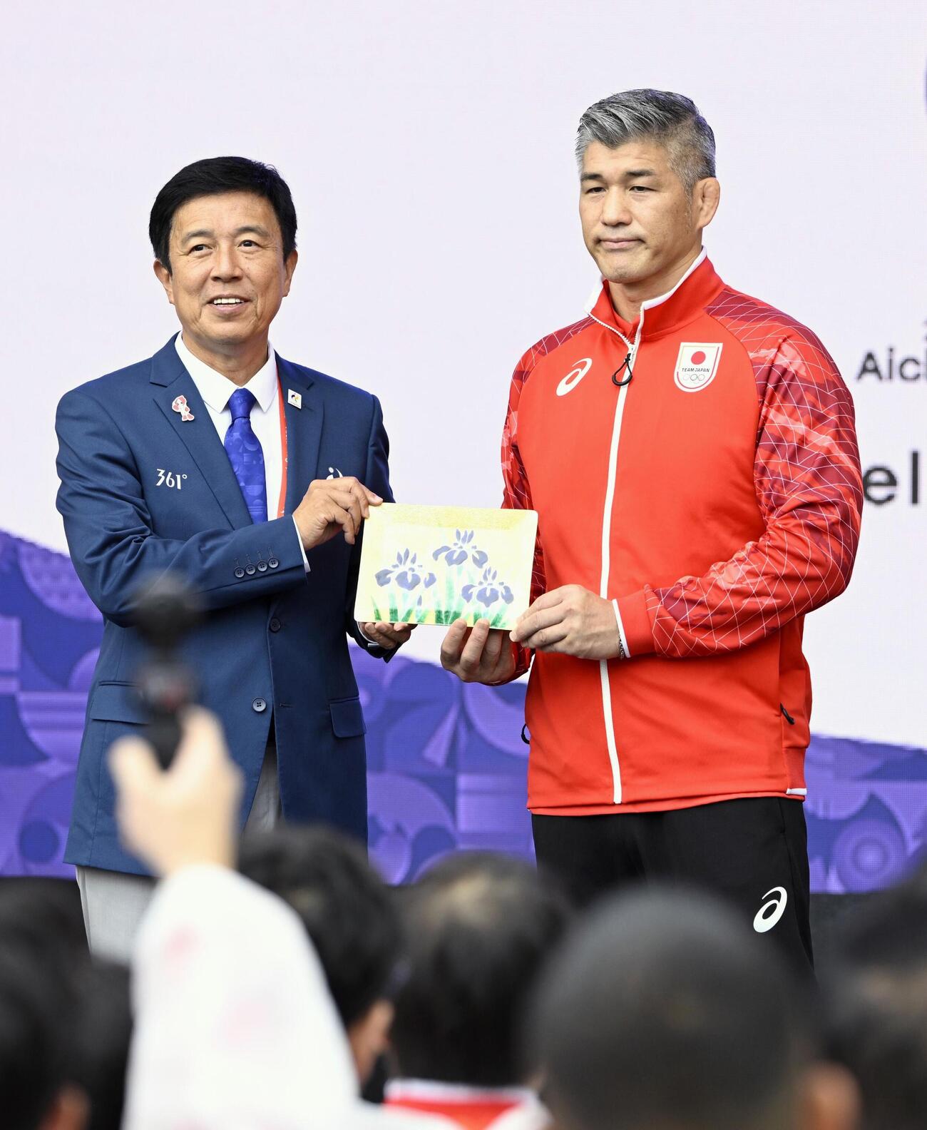 アジア大会の歓迎式典で、名古屋市の広沢一郎市長（左）から記念品を受け取る日本選手団の井上康生団長＝16日午前、名古屋市（共同）
