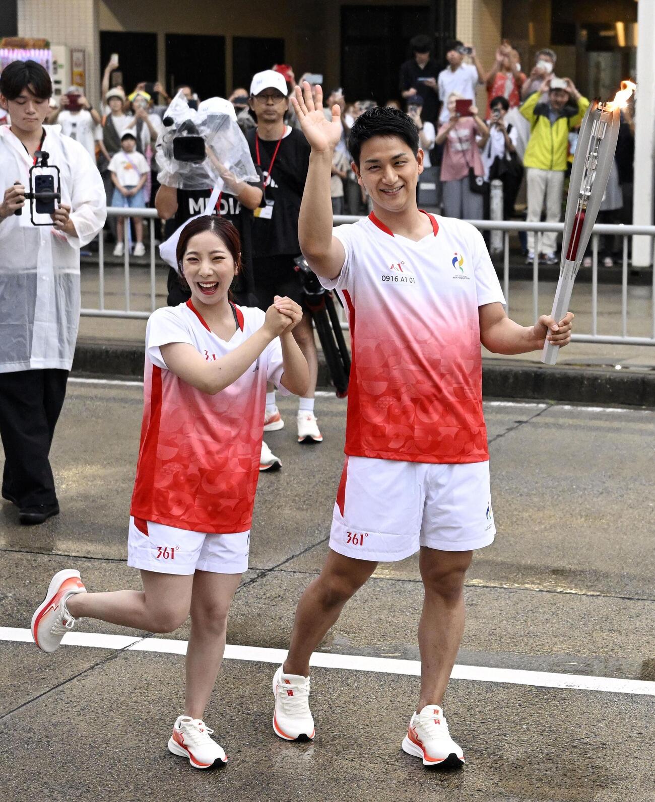 19日に開幕する愛知・名古屋アジア大会の聖火リレーで、ランナーを務めたミラノ・コルティナ冬季五輪で金メダルの三浦璃来さん（左）と木原龍一さん＝16日午後、名古屋市瑞穂区