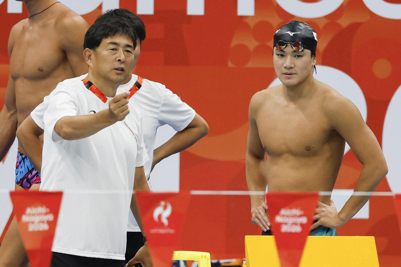 平井伯昌コーチ（左）から指示を受ける競泳男子の松下知之＝東京アクアティクスセンター（共同）