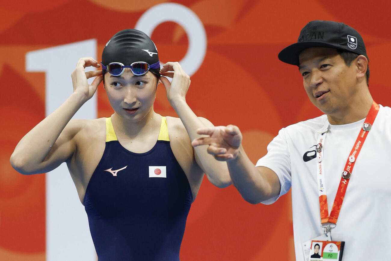 練習でコーチから指示を受ける競泳女子の池江璃花子（左）＝東京アクアティクスセンター（共同）