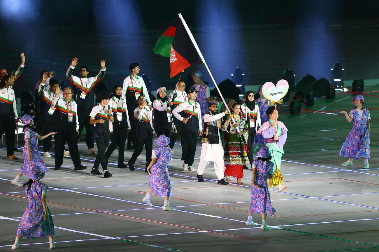 アジア大会開会式　アフガニスタンの選手たちの導線を確保するキャスト（ロイター）